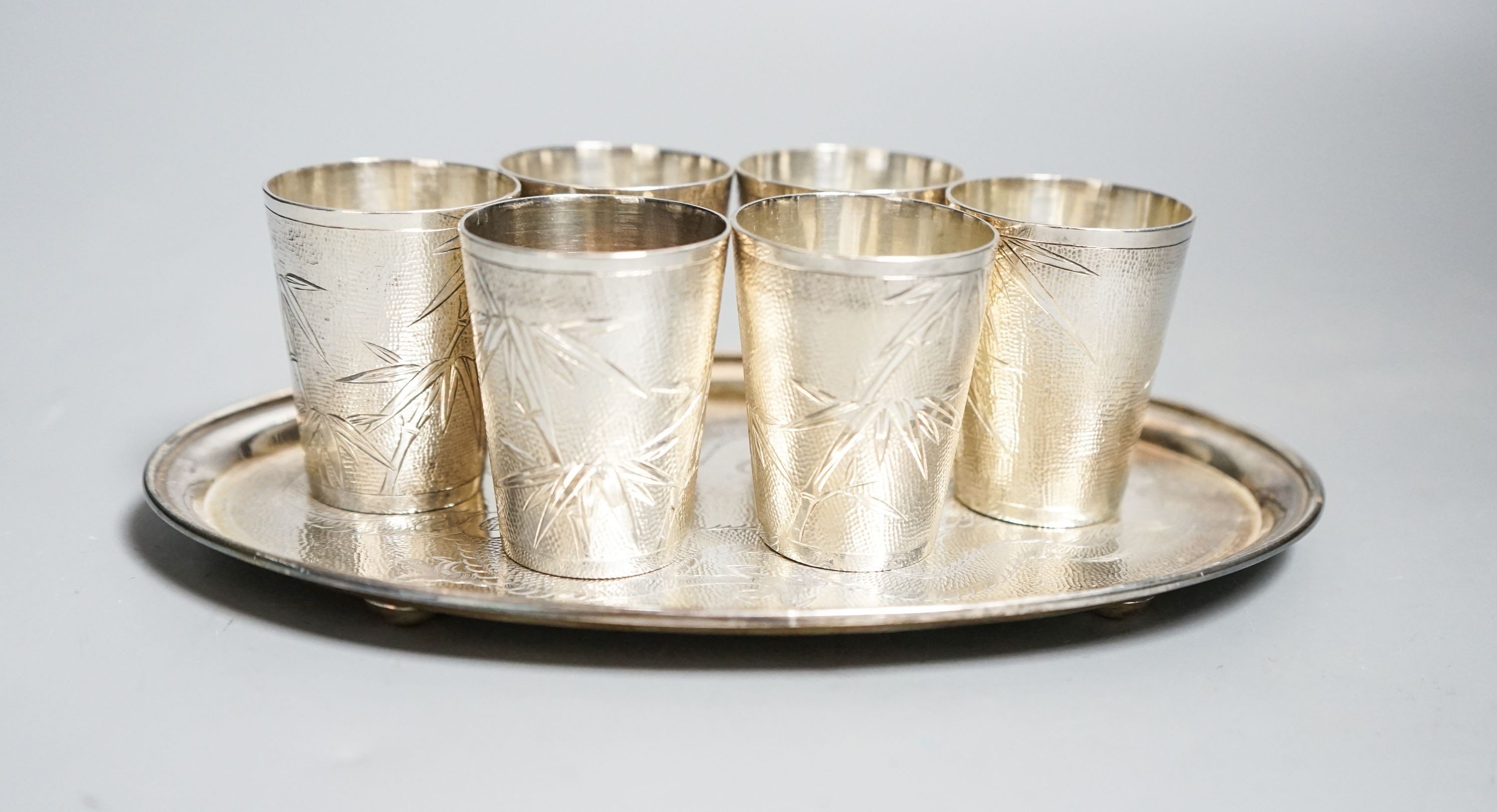 A set of six Chinese white metal tots by Tack Hing, 50mm and a small oval tray by Kingsburg, Hong Kong, 10.5oz.